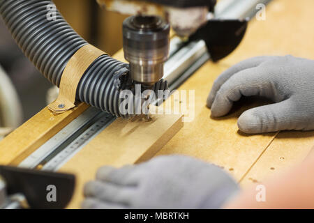 Carpenter avec la perceuse et le conseil à l'atelier Banque D'Images