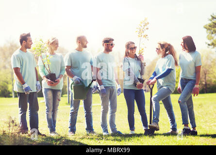 Groupe de bénévoles avec des arbres et rake in park Banque D'Images