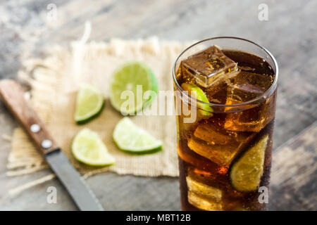 Cuba libre. Cocktail au rhum, citron vert et de la glace sur une table en bois Banque D'Images
