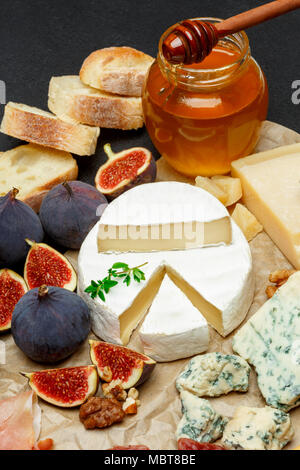 Fromage Brie sur une planche en bois avec des figues fraîches et de miel Banque D'Images