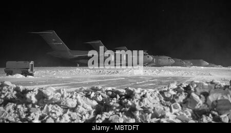 C-17A Globemaster III et C-5M Super galaxies s'asseoir sur la ligne de vol, le 5 janvier 2018, à Dover Air Force Base, Del. huit pouces de neige sont tombés à Douvres avec la permission de la tempête Grayson. (U.S. Air Force photo de Roland Balik) Banque D'Images