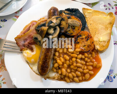 Le petit déjeuner anglais complet en œuf frit, bacon, haricots blancs, pain blanc, boudin noir, saucisse grillée, tomates et champignons servi dans le Yorkshire du Nord Banque D'Images