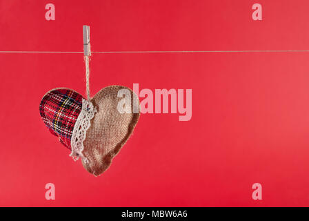 Coeur bloqué sur corde isolé sur fond rouge et l'espace pour le texte. Concept de la Saint Valentin. Banque D'Images