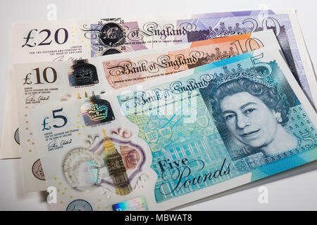 €1 pièces placées aléatoirement sur UK £5, £10, £20 et note Banque D'Images