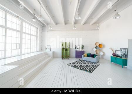 Photo studio lumineux ou dans le salon intérieur avec grande fenêtre, haut plafond, plancher en bois blanc canapé moderne, d'autres meubles. Banque D'Images