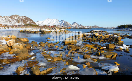 Vue panoramique du fjord à marée basse en hiver avec des montagnes en backgrond et belles pierres et de la glace en premier plan , îles Lofoten, Norvège Banque D'Images