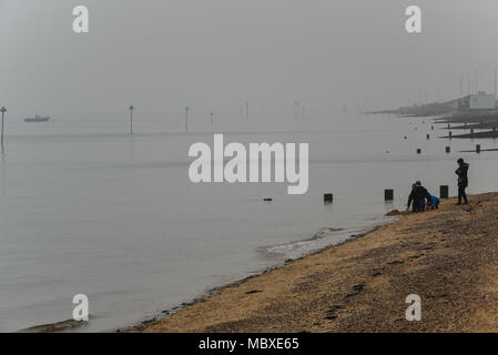 Le brouillard et la brume sur l'Essex n'a pas dissuader les gens jouer sur la plage à Southend on Sea par l'univers trouble de l'estuaire de la Tamise Banque D'Images