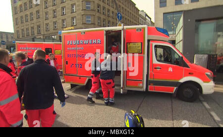 12 avril 2018, l'Allemagne, Hambourg : les médecins d'urgence traiter une personne blessée avec un couteau, dans une ambulance à l'extérieur de l'arrêt de S-Bahn de Jungfernstieg. L'épouse du suspect est mort jeudi après l'agression au couteau dans le centre-ville de Hambourg, a annoncé la police sur Twitter. L'enfant du couple serait mort de blessures. Photo : TNN/dpa-Zentralbild/dpa Banque D'Images