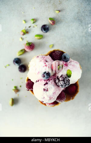 Glace à la rose aux fruits rouges, fraises, bleuets, framboises, pistaches dans waffle panier. Concept des aliments en été, l'espace de copie. Sans gluten saine de la crème glacée aux fruits Banque D'Images
