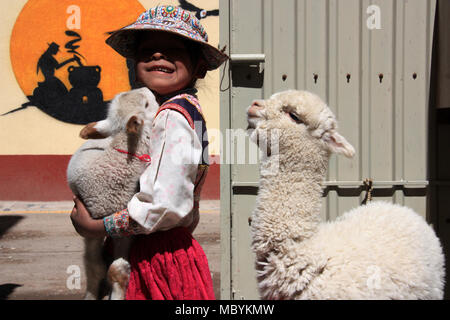 Une petite fille est fier de présenter son bébé agneau et Lama bébé à l'appareil photo Banque D'Images