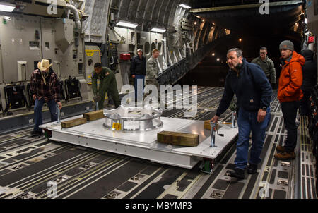 89e et 3e Escadron port aérien de l'Escadron de transport aérien des aviateurs, ainsi que des employés de la NASA, déplacer une charge dolly dans un C-17 Globemaster III sur Joint Base Andrews, dans le Maryland, le 3 avril 2018. La charge dolly est utilisé comme plate-forme de rassemblement pour la sonde solaire Parker afin d'exploiter l'analyse de l'employé de la NASA sur le satellite. Banque D'Images