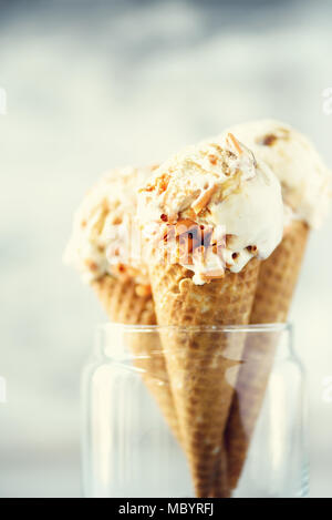 Sauce au caramel crème glacée au cornet gaufré avec les grains de café sur fond noir en gris. Concept des aliments en été, l'espace de copie. Sans gluten sains des glaces. Banner Banque D'Images