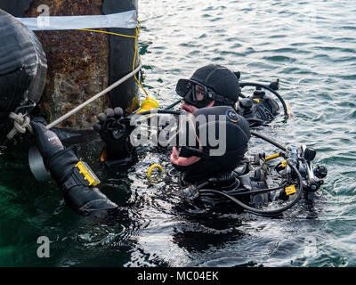 La Marine américaine électricien de construction 2e classe Timothy Dailey (haut) et de la Marine Builder 2e classe Aaron Brown (en bas), tous deux assignés à l'équipe de construction sous-marine (UCT) 2, préparer à descendre dans l'eau pour une plongée à Commandant, activités liées à la flotte de Sasebo (SCFA), Japon, le 16 janvier 2018. UCT-2 prévoit la construction, l'inspection, l'entretien, et la réparation des installations sous-marines et le bord de l'eau à l'appui de la Flotte du Pacifique. (U.S. Caméra de combat de la marine, spécialiste des communications de masse de photo de 1re classe Arthurgwain L. Marquez) Banque D'Images