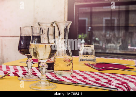 Deux verres de vin rouge et blanc servi sur une table dans un restaurant italien traditionnel. Banque D'Images