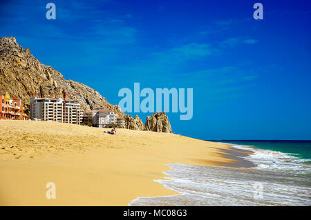 Scène de plage idyllique, golden sands, rocky mountain en toile de fond, la mer turquoise et ciel bleu. Les baigneurs se détendre sur Pedregal beach, Cabo San Lucas, Mexique Banque D'Images