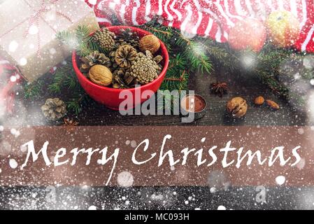 Décoration de Noël - rouge bol plein de cônes de sapin, boîte-cadeau enveloppé dans du papier kraft, des branches de pins, bougie, écrous, d'anis, pommes et bande rouge et blanc Banque D'Images