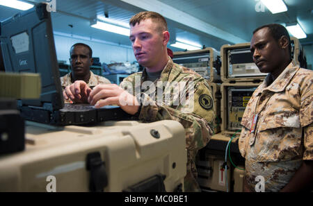 La CPS de l'armée américaine. Taylor Noble, un opérateur de transmission multi-mainteneur et affecté à la Force opérationnelle interarmées - Corne de l'Afrique (CJTF-HOA) Direction générale des Communications, présente les membres de l'Armée de Djibouti (FAD) comment acquérir un signal satellite grâce à l'aide d'une antenne au cours d'une de militaires à militaires Cours de change au Camp Lemonnier, Djibouti, le 8 janvier 2018. Tout au long d'une période de deux semaines, des experts de la communication a informé les membres du service djiboutien sur la façon de mettre en place, exploiter, entretenir et dépanner le matériel de réseau pour augmenter les capacités de communication entre l'Union africaine Mlle Banque D'Images