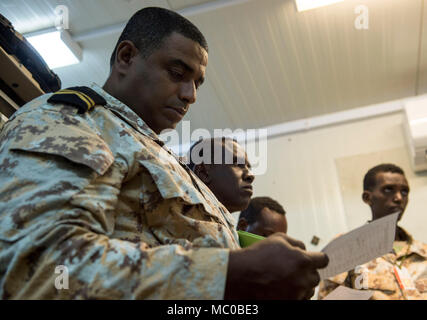 Un Djibouti Armed Forces (FAD) états reviews une feuille de commandes durant une entrée de militaires à militaires cours d'échange avec des soldats américains affectés à la Force opérationnelle interarmées - Corne de l'Afrique (CJTF-HOA), la Direction des communications au Camp Lemonnier, Djibouti, le 9 janvier 2018. Tout au long d'une période de deux semaines, des experts de la communication a informé les membres du service djiboutien sur la façon de mettre en place, exploiter, entretenir et dépanner le matériel de réseau pour augmenter les capacités de communication entre l'Union africaine en Somalie. (U.S. Air Force photo illustration par le sergent. Timothy Moore) Banque D'Images