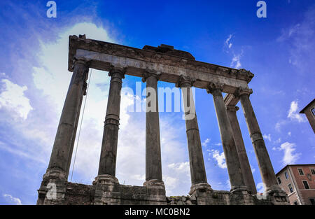 Vue imposante du Temple de Saturne dans le Forum Romain, contre un ciel bleu profond des ruines anciennes montrant des colonnes corinthiennes restantes Banque D'Images