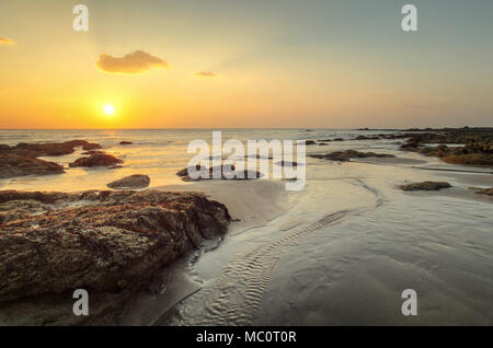 Plage de golden sunset light durant la marée basse montrant jet de l'eau et les rochers couverts d'algues de mer. Kantiang Bay, Ko Lanta, Thaïlande. Banque D'Images