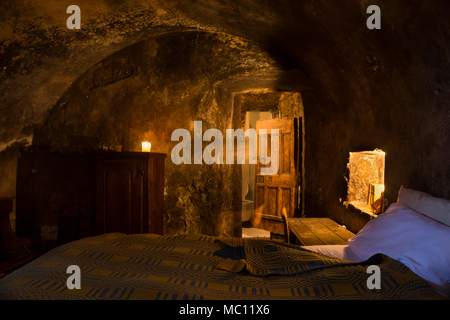 Grotte chambre médiévale avec des bougies allumées, des portes en bois massif et d''un plafond voûté en Santo Stefano di Sextantio diffusées, l'hôtel Santo Stefano Banque D'Images