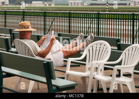New York, USA - 20 août 2006 : Caucasian man lit les informations concernant les chevaux à l'Ellis Park race track comme il attend que le racing à b Banque D'Images
