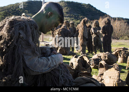 LCpl. Zachary Radack, 21 ans, de l'Aliso Viejo, Californie, a chargé professionnellement avec tireur de surveillance et d'acquisition régimentaire Company, 1er Régiment de Marines, ajuste son ghillie suit en vue d'un exercice sur le mouvement le 22 janvier 2018. RSTAC est conçue pour renforcer la maîtrise des opérations pour sniper scout exercices de niveau de service jusqu'à vivre la mission à plein feu adulte, les rapports de surveillance et de reconnaissance et d'exploitation du centre de contrôle d'un grand angle d'incendies de précision. (U.S. Marine Corps photo par Lance Cpl. Lukas Kalinauskas.) Banque D'Images