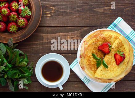 Pile de crêpes dorées avec des fraises et de la confiture de fraise, décoratives feuille de menthe. La vue de dessus Banque D'Images