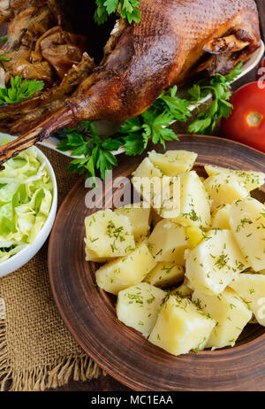 Des pommes de terre dans un bol d'argile cuite, salade de chou et d'oie. La vue de dessus Banque D'Images