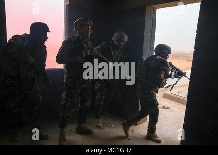 Les membres des forces de sécurité iraquiennes's Brigade 61e un bâtiment clair des forces opposées au cours de l'activité de formation qui a abouti au Camp Taji, l'Iraq, le 22 janvier 2018. Le programme à développer et à améliorer la capacité des partenaires nationaux comprend : le leadership, l'éthique et droit de la guerre et la formation. De plus, les recrues sont enseignées la navigation terrestre, la formation médicale de base, les compétences de l'infanterie et des petites unités tactiques. (U.S. Photo de l'armée par la CPS. Audrey Ward) Banque D'Images