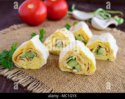 Rouleaux de pita avec du fromage et de concombre sur un fond de bois Banque D'Images