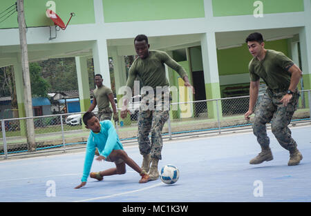 Les Marines américains Lance Cpl. Daniel Adomina (à gauche) et le Cpl. Simon Gomez jouer au foot avec un garçon à l'école Wat Khlong plu dans la province de Chanthaburi, Royaume de Thaïlande, le 24 janvier 2018. Adomina est un électricien de l'Escadron de soutien de l'aile Marine 171, et est originaire de Hamilton, New Jersey. Gomez est un ingénieur de combat avec MWSS-171, et est originaire de Kendall, en Floride. Les projets d'action civique humanitaire menée au cours de l'or Cobra 2018 soutenir les besoins et intérêts humanitaires de la population thaïlandaise. (U.S. Marine Corps photo : Capt Timothy irlandais) Banque D'Images