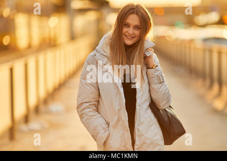 Jeune fille debout sur la rue place, regarder et sourire de l'appareil photo Banque D'Images