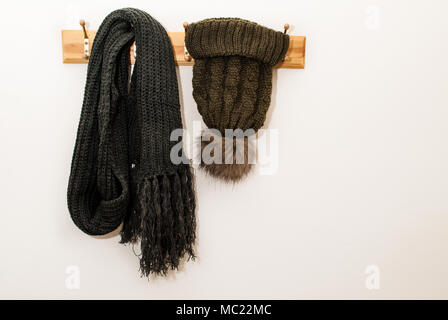 Écharpe d'hiver et de la laine avec une boule de poils et accroché sur un chapeau sur fond blanc Banque D'Images