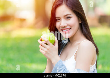 Belles femmes asiatiques model hand hold Green Apple en plein air parc de la saine alimentation alimentation fruits bio concept Banque D'Images