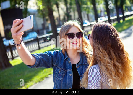 Portrait of cute joli meilleurs amis des filles, câlin et s'amuser ensemble, de baisers, de sourire, de joie, de porter des lunettes de soleil et d'été sœurs faire des photos,de leur Banque D'Images