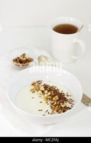 Bouillie de semoule traditionnel avec du beurre, les noix et graines de lin. Un petit-déjeuner utile de porridge et de thé. Style rustique. Banque D'Images