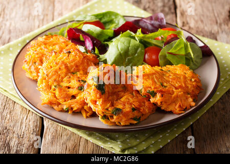 Servant des plats végétariens croustillant de crêpes de pommes de terre et salade de légumes frais sur une plaque horizontale de près. Banque D'Images