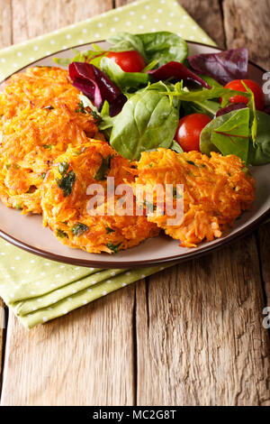 Beignets de patates douces avec les verts et salade fraîche sur une plaque verticale close-up. Banque D'Images