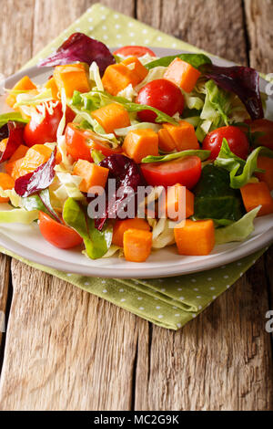 L'alimentation saine : végétarien salade de patate douce avec des légumes frais close-up sur une plaque sur une table verticale. Banque D'Images