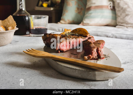 Steak grillé sur planche à découper. Scellé avec un solide, juteux et rose feu à l'intérieur. avec des croustilles de pommes de terre. Banque D'Images