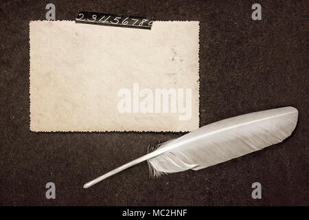 La page de l'ancien album photo avec cadre photo rétro en blanc (pour photo ou notes) collée avec du ruban adhésif avec des numéros et à la plume d'altitude. Grunge style. Banque D'Images