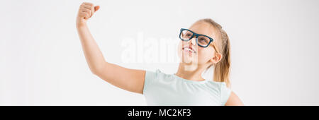 Close-up of a smart, jeune fille à lunettes tenant son bras vers le haut dans un super-héros sur une forte posent blanc fond vide Banque D'Images