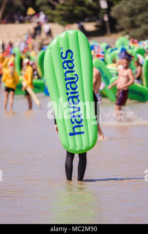 Amateurs de l'exercice inflatable Havianas tongs dans les vagues à l'Australie, l'événement annuel jour coin douillet, Torquay, Surf Coast, Victoria, Australie Banque D'Images