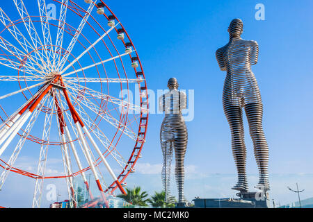 BATUMI, GÉORGIE - 22 septembre 2015 : Déménagement metal sculpture Ali et Nino ancien nom l'homme et de la femme par Tamara Kvesitadze et grande roue à Batumi, Géorgie Banque D'Images