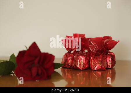 Bonbons cerise et une rose rouge un beau cadeau Banque D'Images