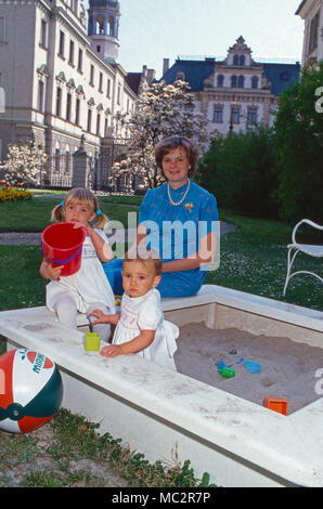 Fürstin Gloria von Thurn und Taxis spielt mit ihren Töchtern Elisabeth Maria Theresia im Sandkasten und im Garten von Schloss Emmeram à Regensburg, Allemagne 1983. La Princesse Gloria von Thurn und Taxis jouant avec ses filles Elisabeth et Maria Theresia dans le bac à sable dans le jardin de château Emmeram à Regensburg, Allemagne 1983. Banque D'Images