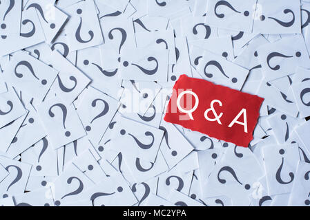 Point d'interrogation sur du papier blanc et Q&A sur papier rouge. questions et réponses concept Banque D'Images