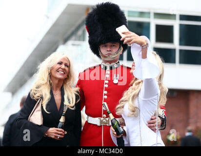 Racegoers ont leurs photos prises avec un soldat au cours de la première journée de la santé Randox 2018 Grand National à Aintree Hippodrome Festival, Liverpool. Banque D'Images