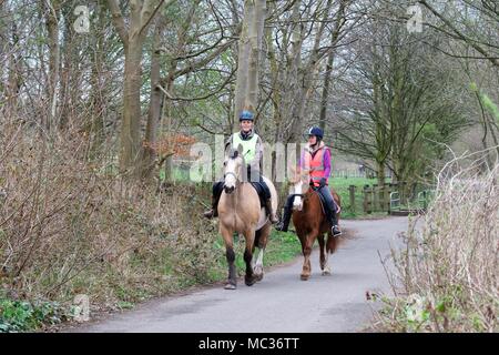 Les femmes deux cavaliers sur un chemin par le côté de la Mersey à Heaton Mersey, Stockport UK Banque D'Images